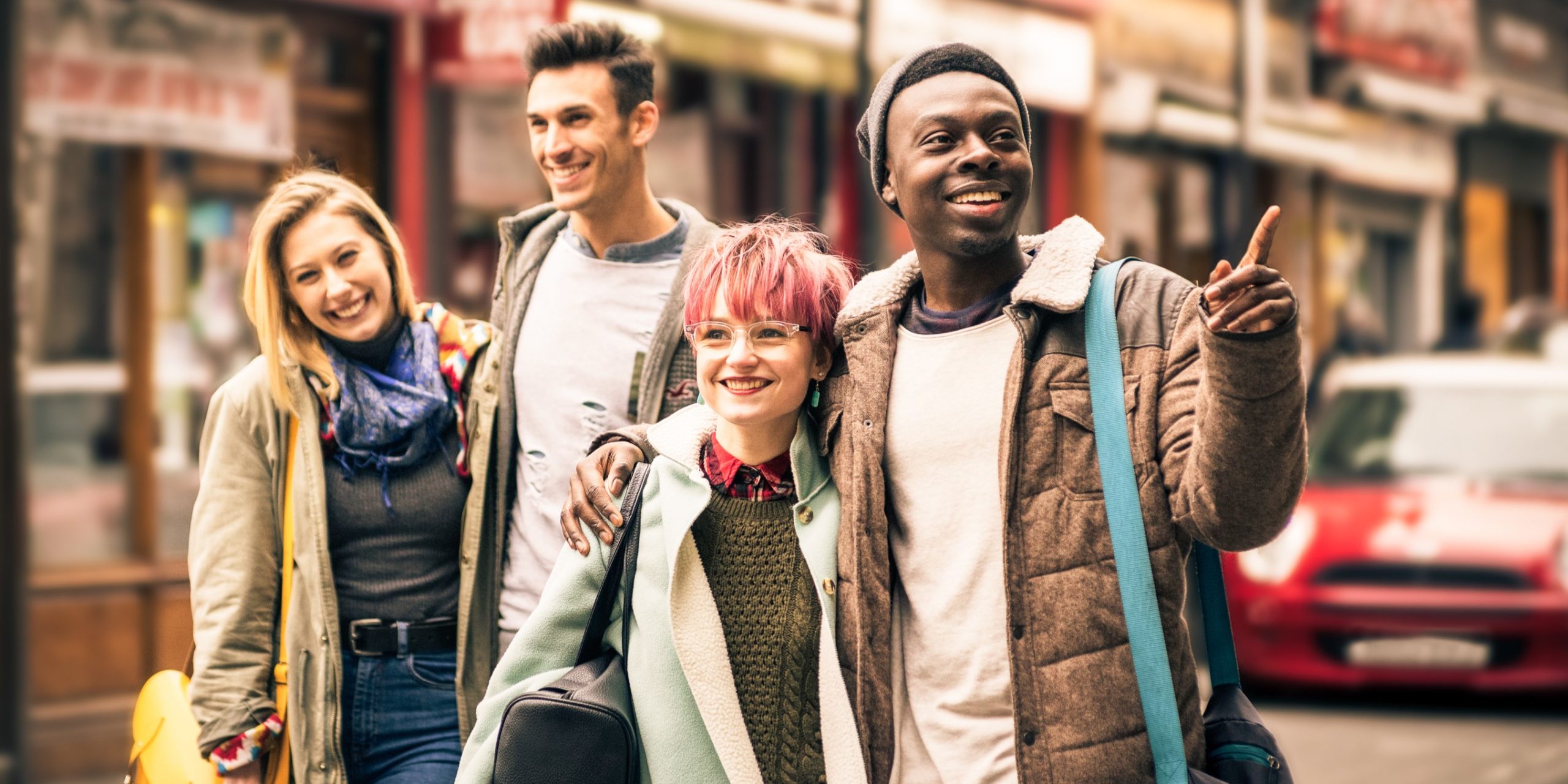 Happy multiracial friends walking on Brick Lane at Shoreditch London.