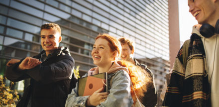 Happy students walking outdoors in college campus