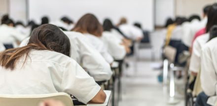 Pupils sitting at desks in an exam hall
